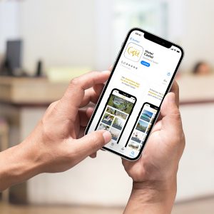 Ein Smartphone zeigt den App Store Eintrag einer gebrandeten Hotel-App von Gastfreund