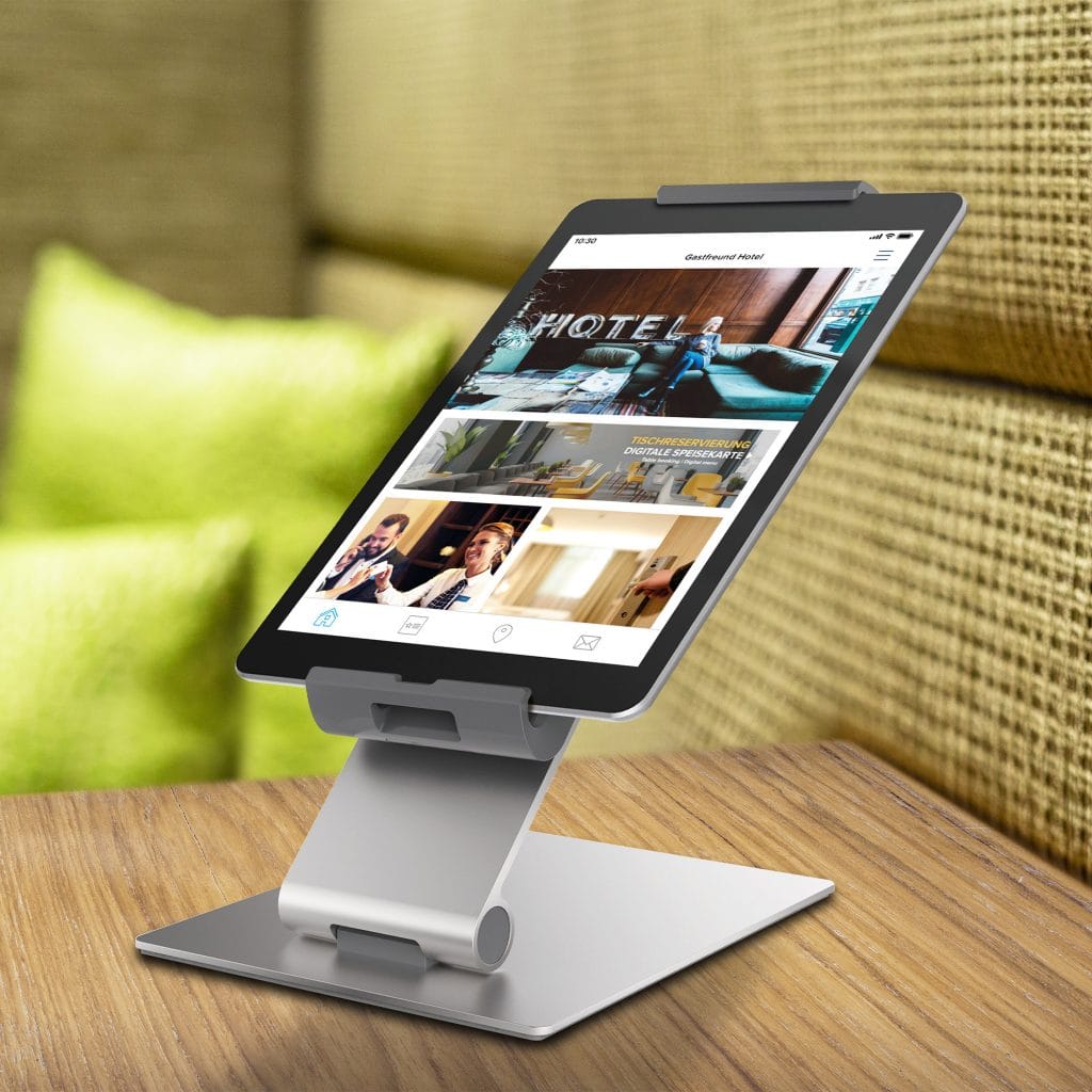 Ein stationäres Tablet auf einem Hotelzimmer zeigt die Digitale Gästemappe von Gastfreund